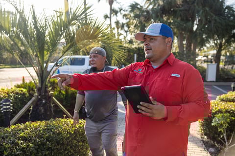 project manager looking over landscape design and crew