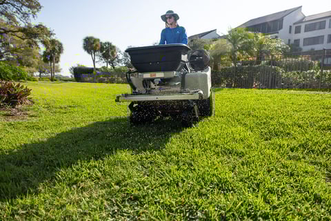 Lawn care technician maintaining the lawn and riding machine 