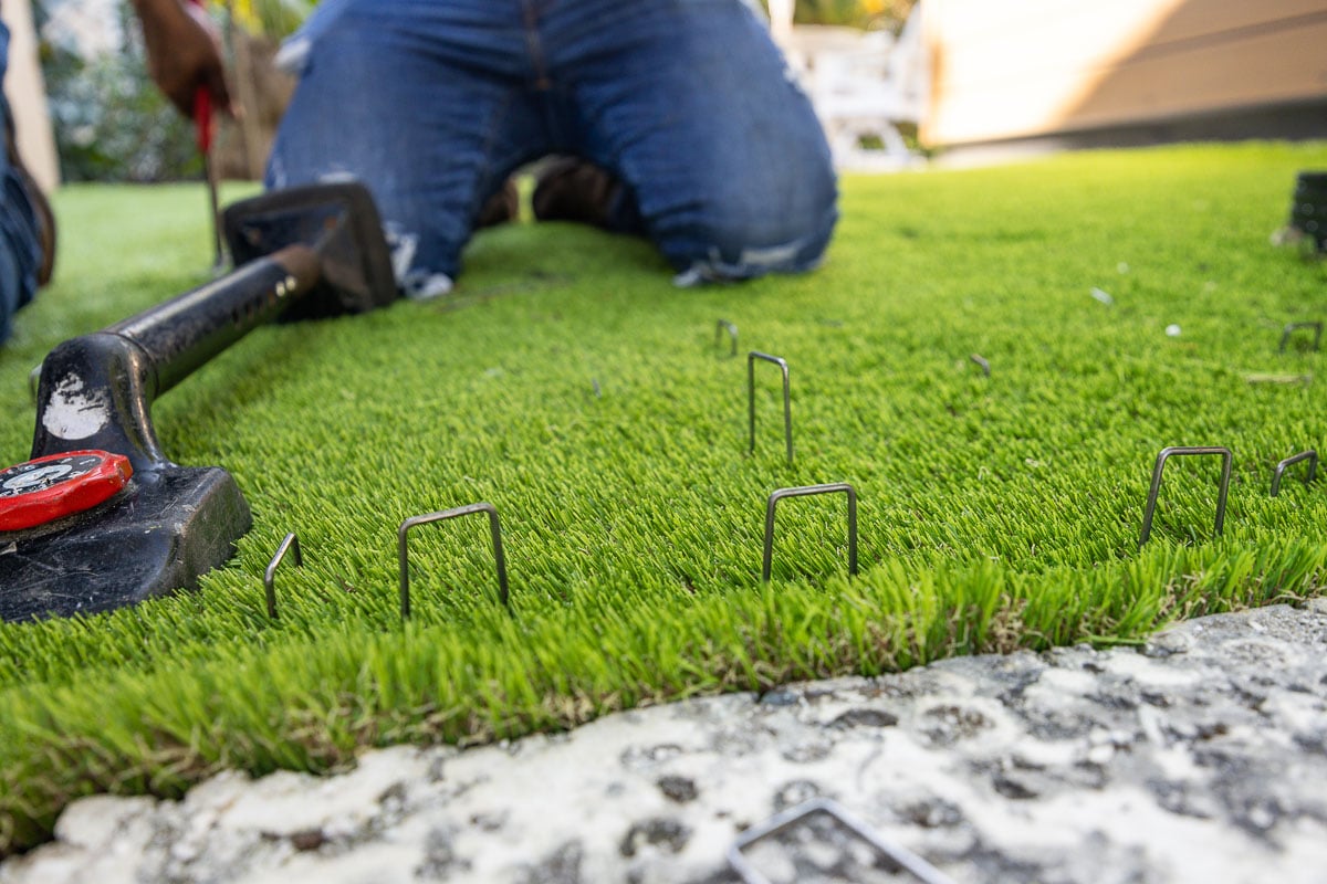 crew installing artificial turf in yard