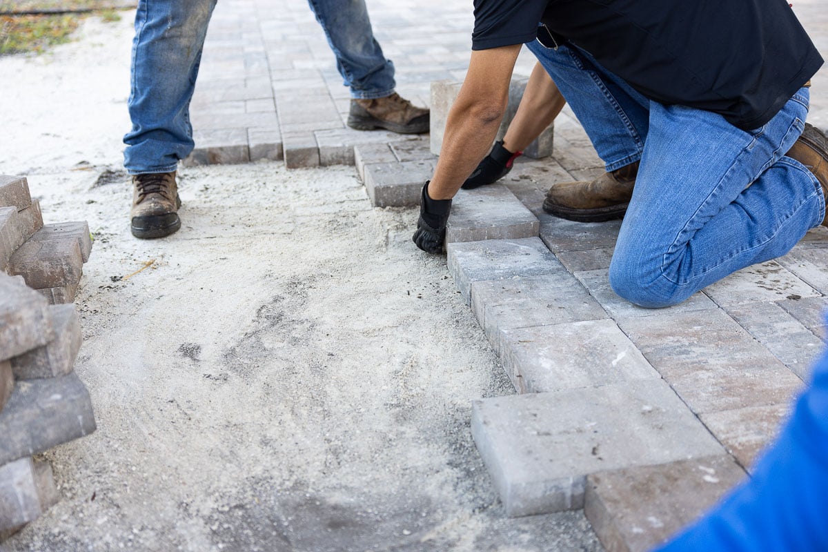 crew paver patio installation with concrete edging