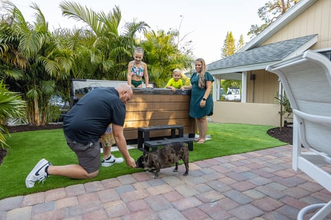 dog next to artificial turf with customer and family 