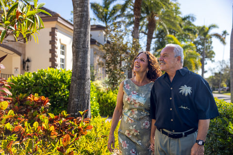 couple walking through garden looking at plants 