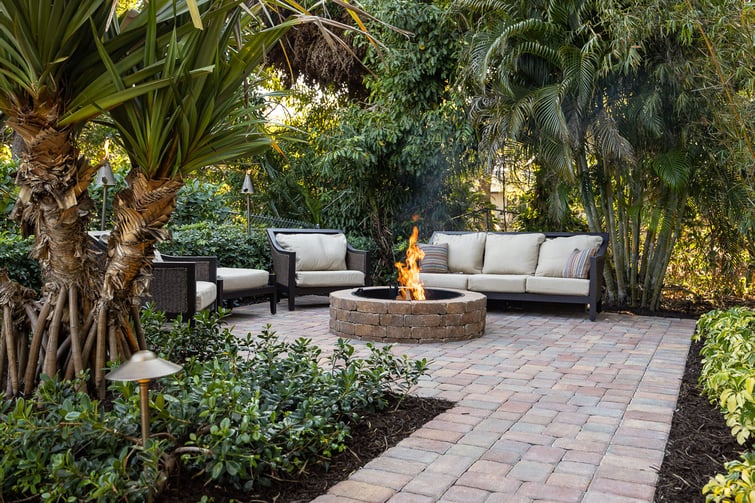 fire pit on patio surrounded by trees and furniture