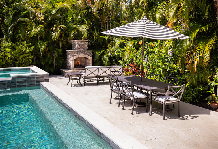 outdoor fireplace on patio next to pool