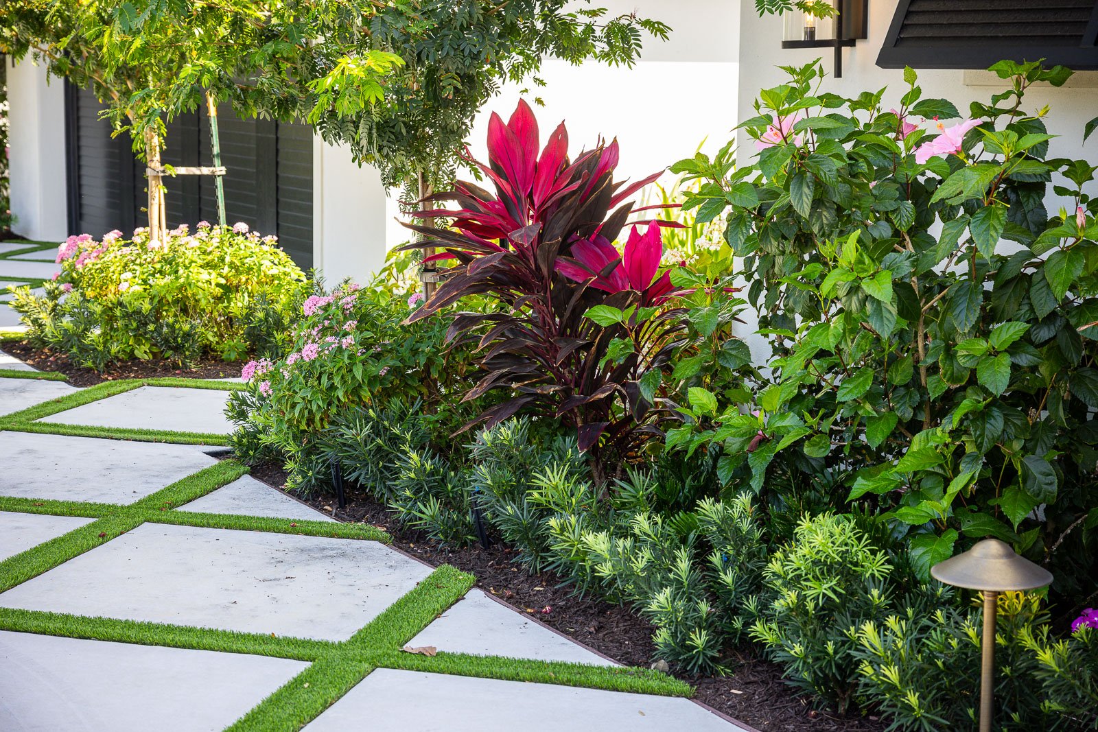 garden bed with mulch and plants along driveway 6