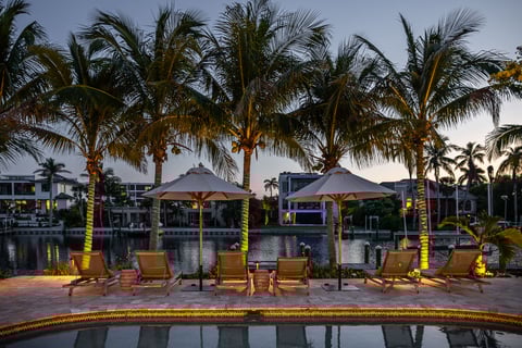 landscape lighting along water with large palm trees