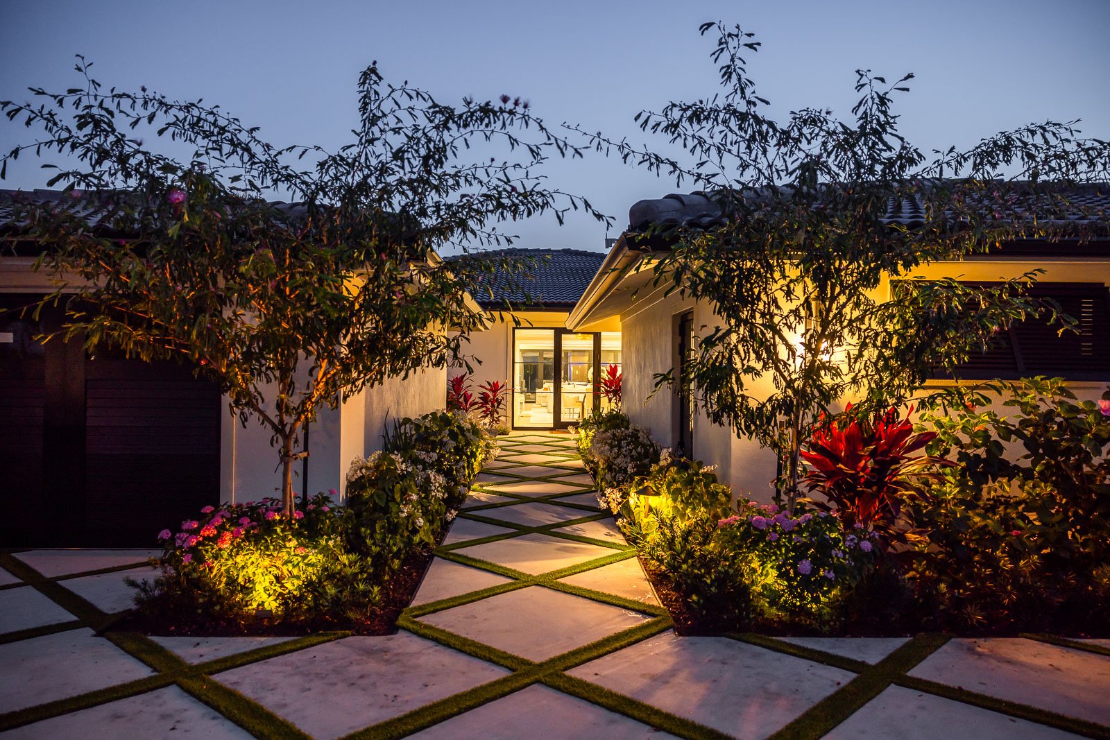 landscape lighting in garden beds along walkway 