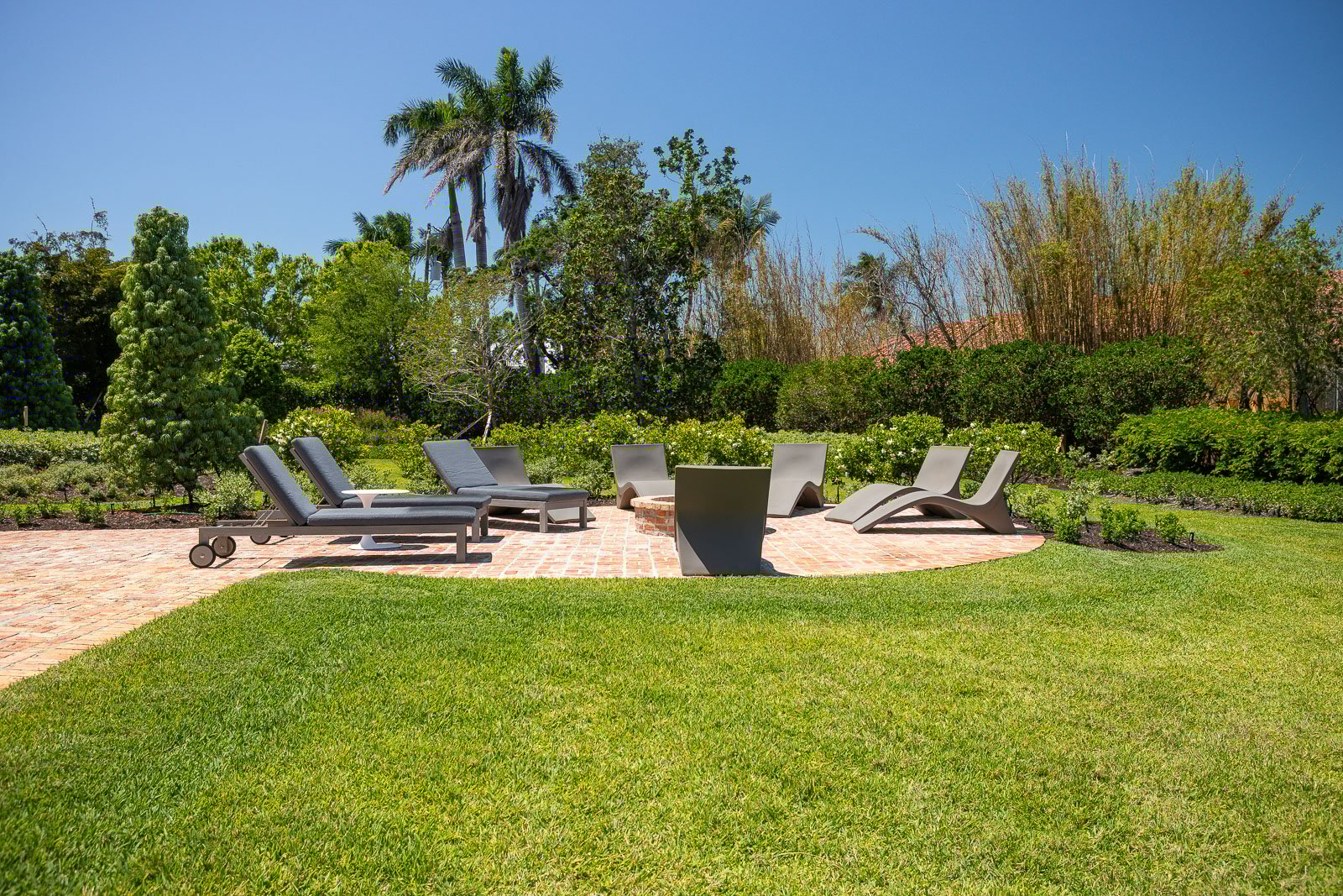 Backyard landscaping green lawn patio fire pit outdoor seating 