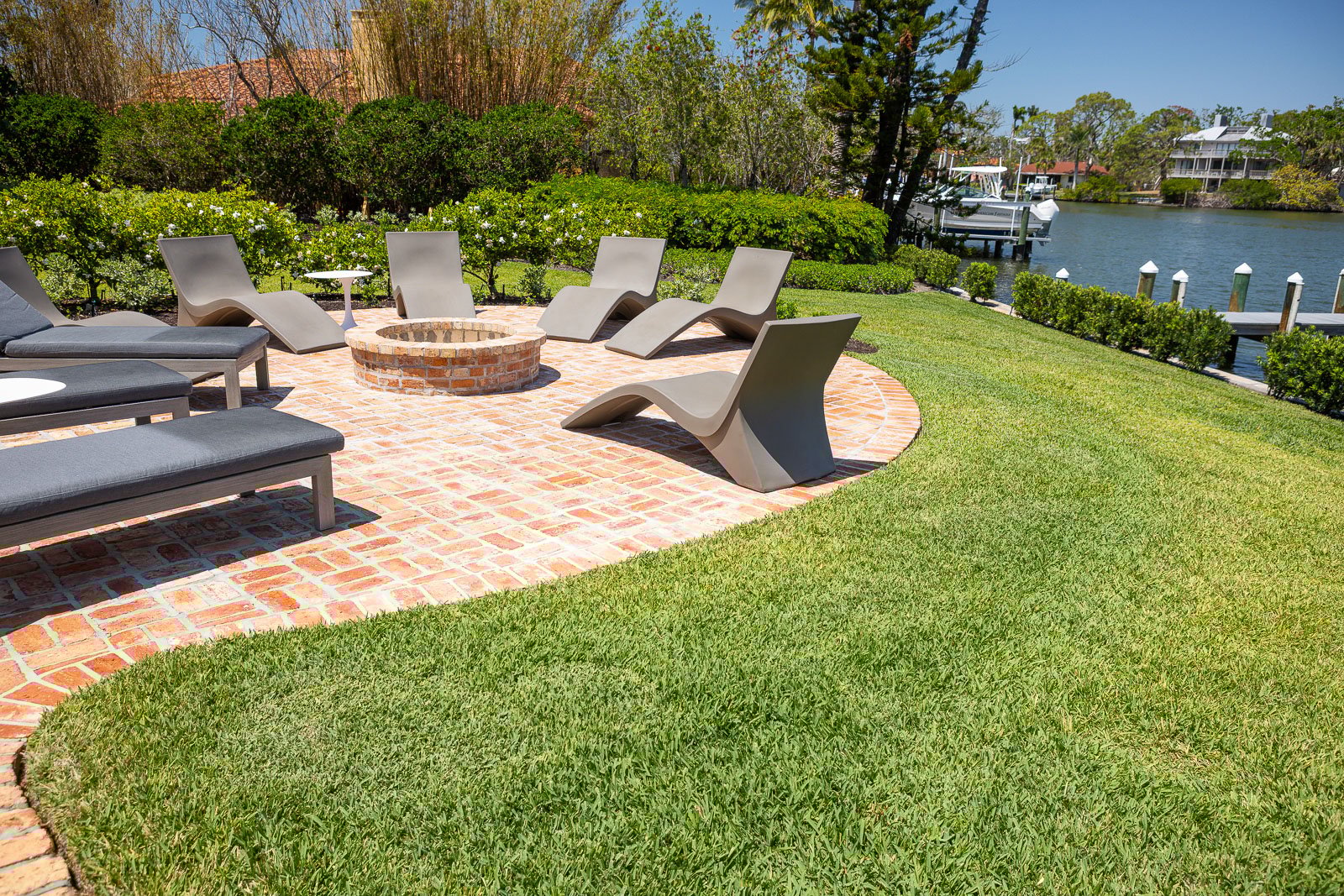 Backyard landscaping green lawn patio fire pit outdoor seating water 2