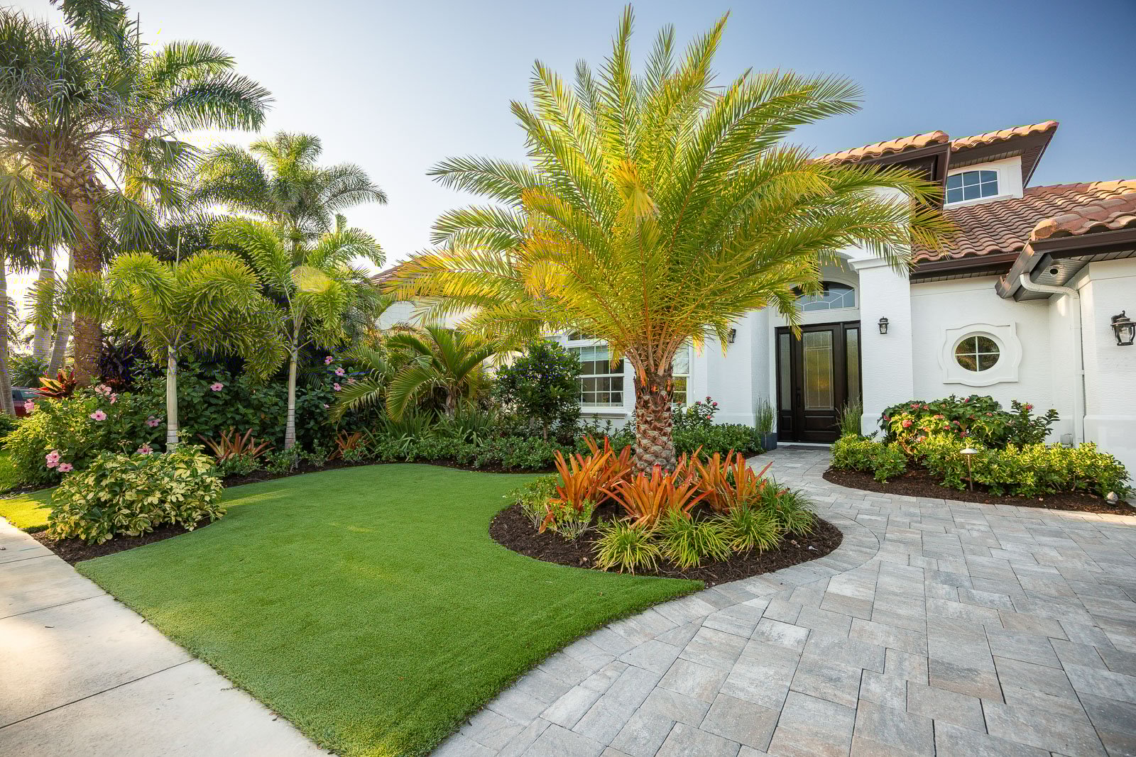 front yard with fresh landscaping and paver driveway