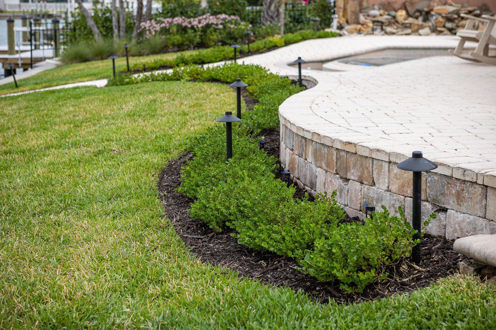 landscape lighting and bed along patio 