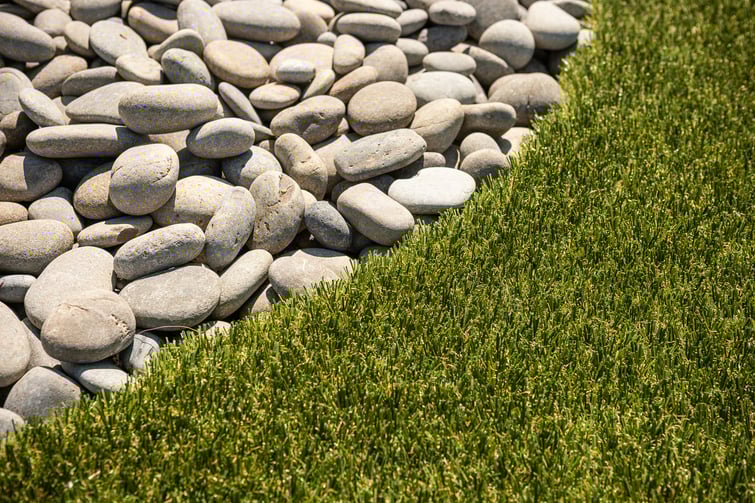 stones in landscape bed next to turf