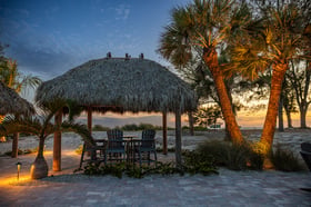 outdoor uplighting on trees tiki hut paver patio beach