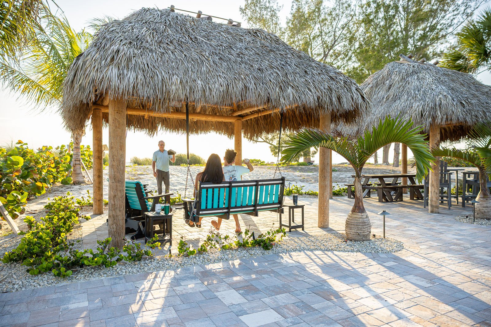 paver patio tiki hut clients playing catch on beach