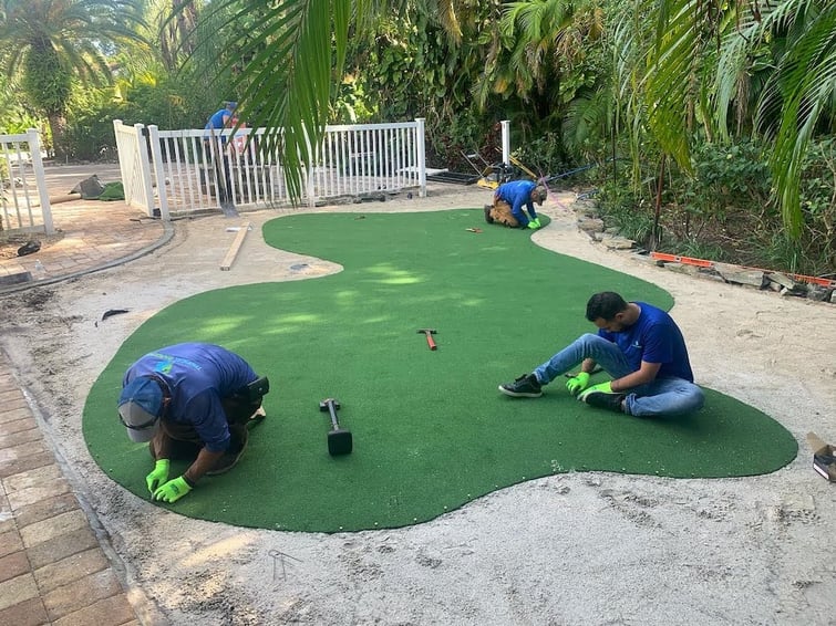 crew installing turf in backyard