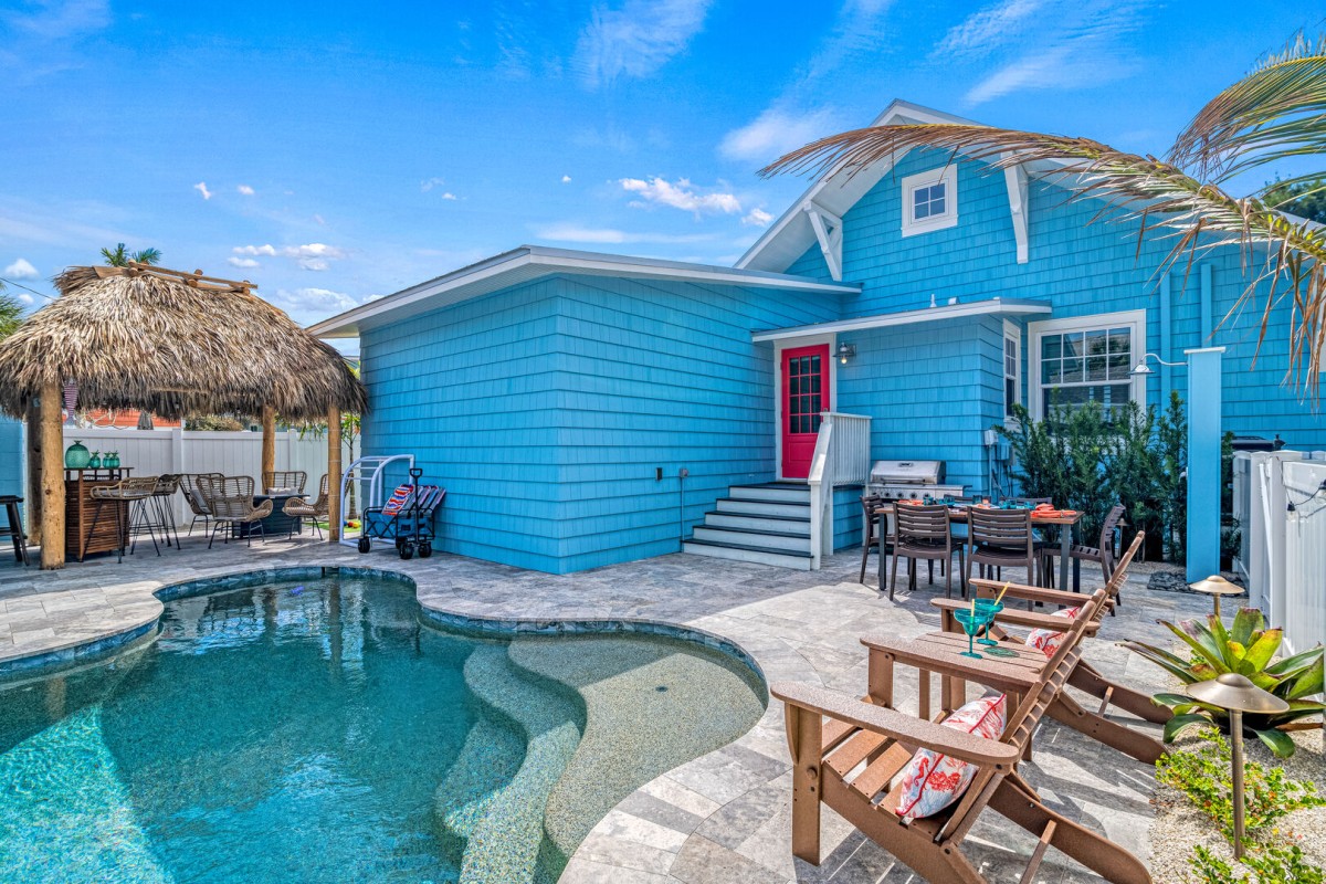 tiki hut by pool and blue house