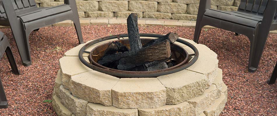 A stone fire pit filled with wood.