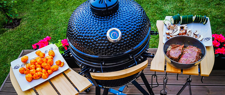 An black charcoal grill with food in a customer built outdoor kitchen in Sarasota, FL.