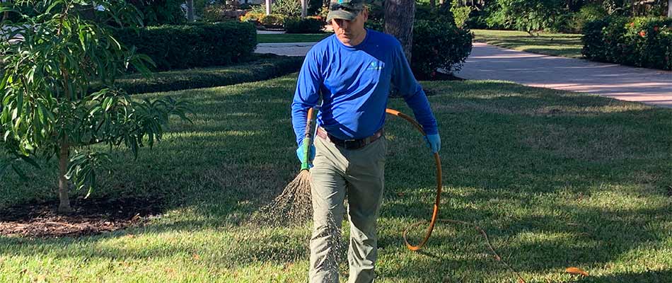 Tropical Gardens professional spraying fertilizer treatment to a lawn in Sarasota. FL.