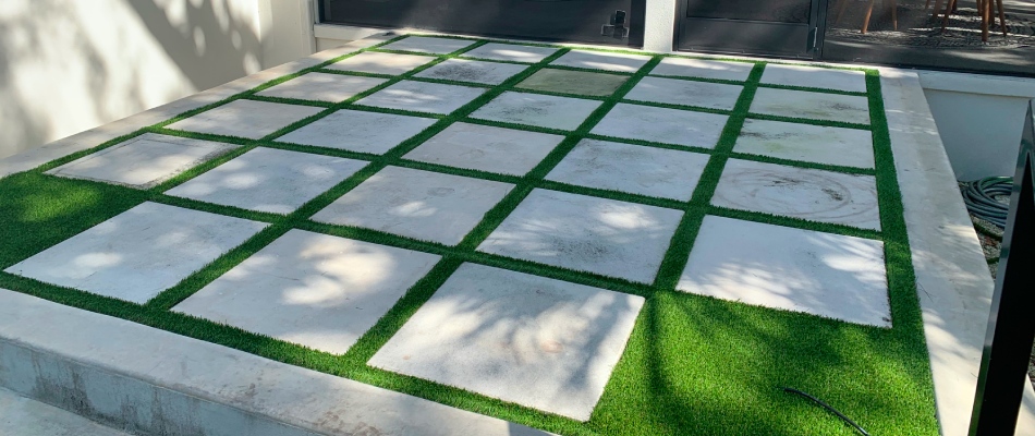 Coralina stone added to turf for patio installation in Sarasota, FL.