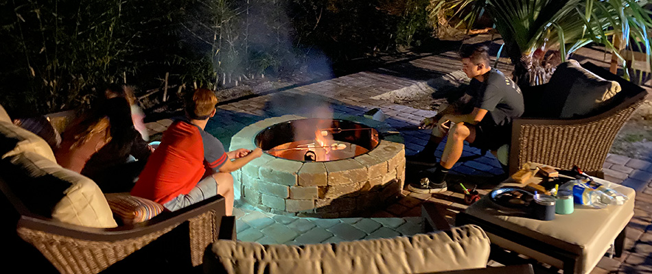 Two boys roasting marshmallows over fire pit near Crescent Beach, Siesta Key, FL.