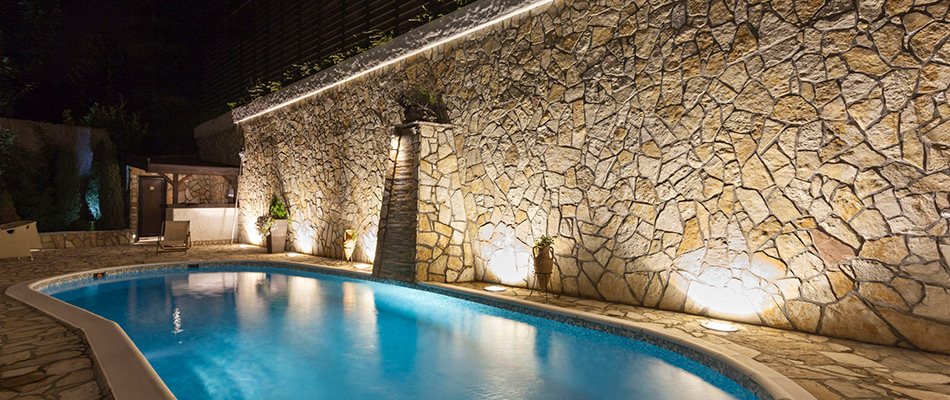 Wall grazing lighting technique installed by pool in Lakewood Ranch, FL.