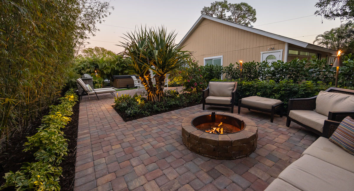 backyard patio with fire pit and tiki torches 